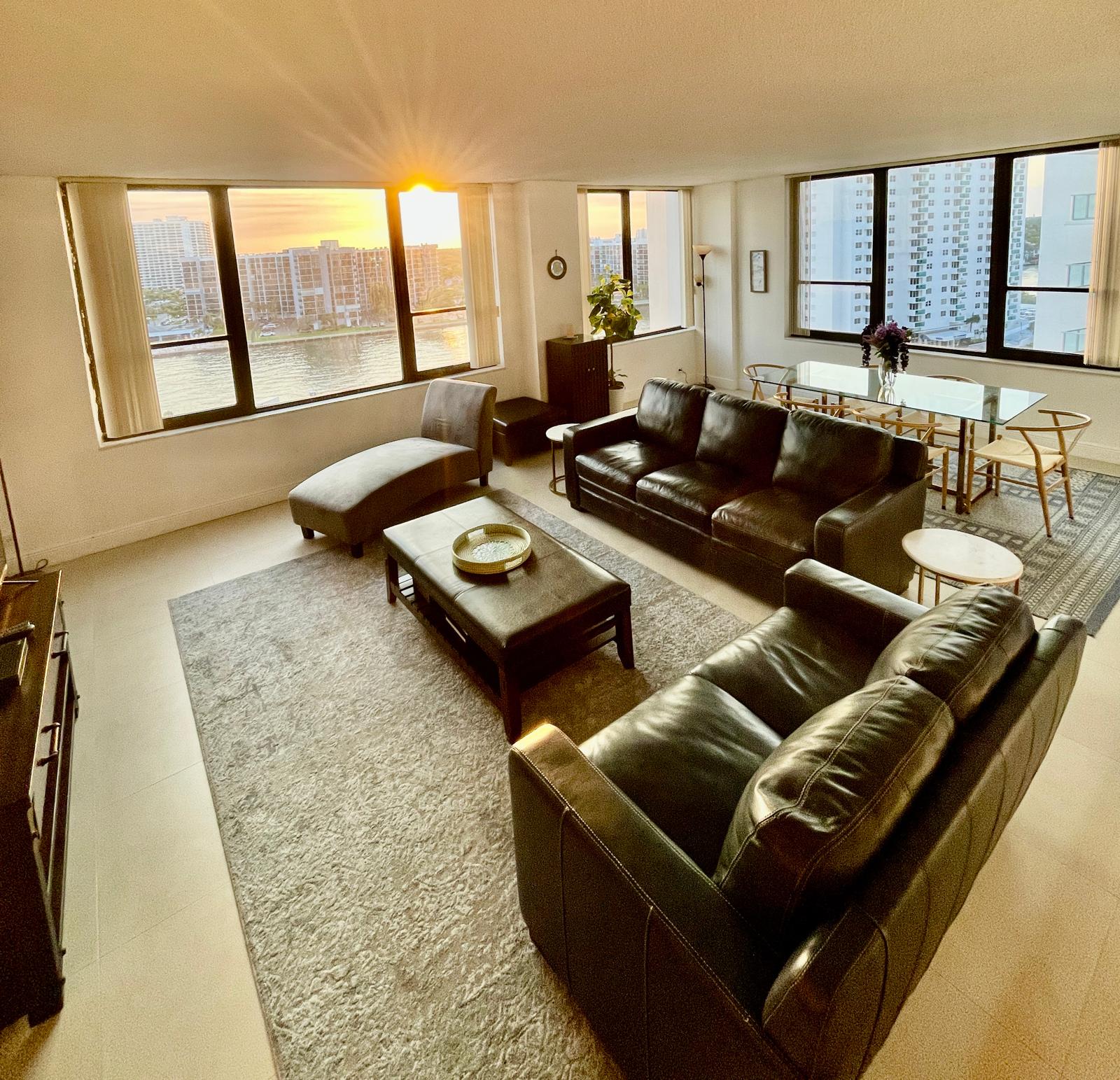 Open living and dining room glowing at golden hour, with sunset views over the Intracoastal waterway