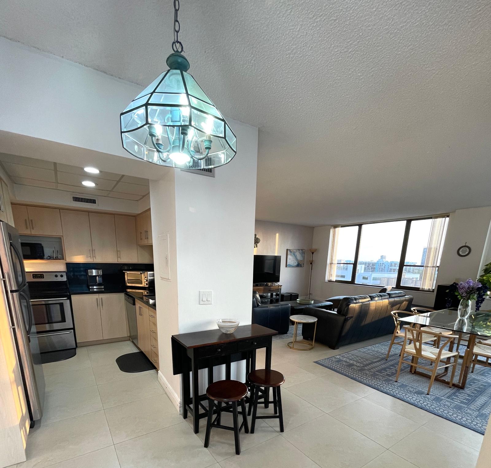 Bright open-plan view across the kitchen, breakfast bar, dining table and living room