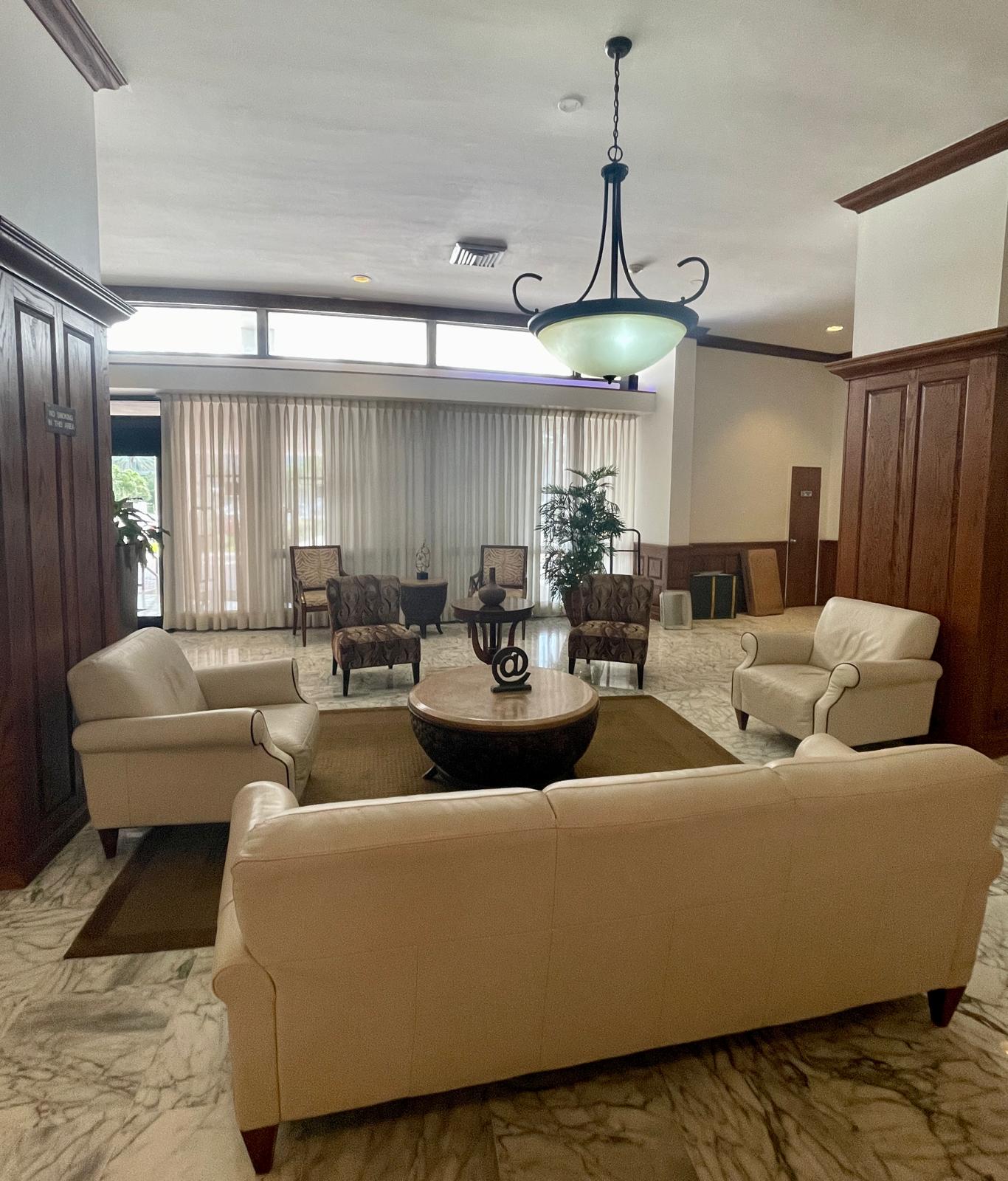 Building lobby with cream leather seating, wood paneling and marble floors